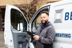 service technician standing beside a company work van